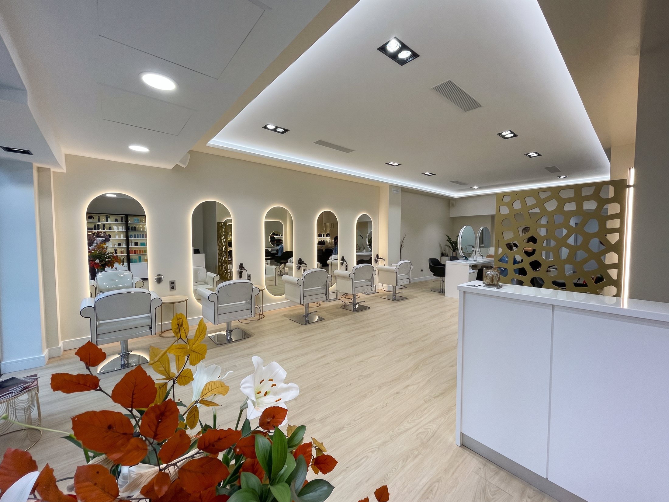 El salón: tocadores con espejos en arco, sillones blancos y recepción